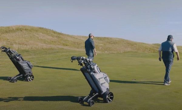 Zero Friction STRIDE remote follow-me golf trolley and bag on a green fairway with golfers walking nearby